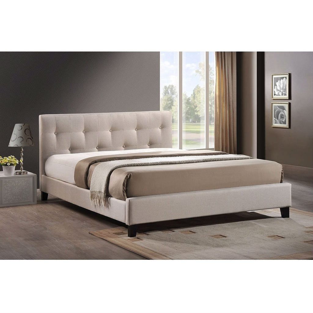 Beige upholstered bed in a modern bedroom setting with a lamp and window.